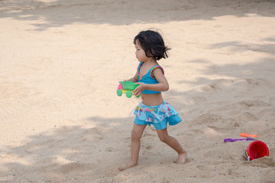 Girl playing with toy on beach