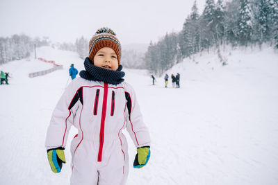 Portrait of woman skiing on snow covered field