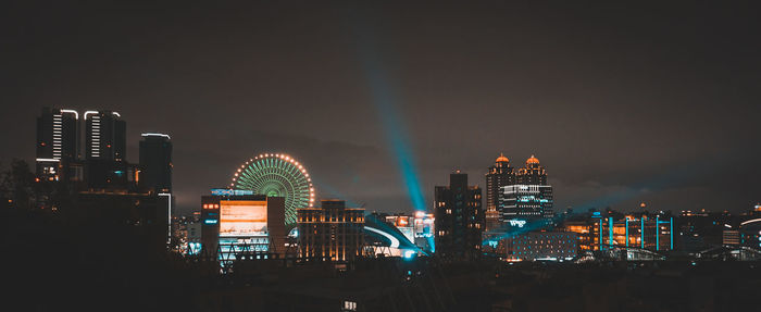 Illuminated buildings in city against sky at night