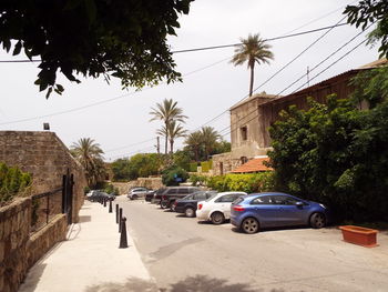 Cars on road by building against sky