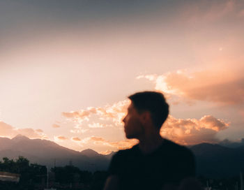 Silhouette man standing against sky during sunset