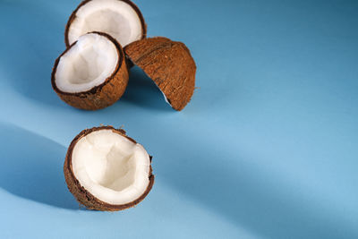 Coconut fruits on blue vibrant plain background, abstract food tropical concept