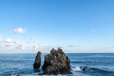 Rocks on sea shore against sky