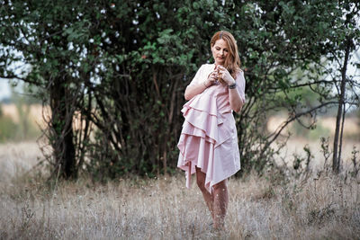 Portrait of a woman standing on field