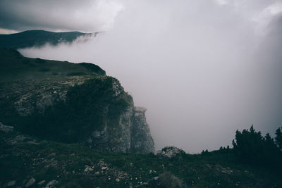 Scenic view of foggy cliff