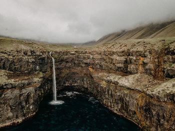 Scenic view of waterfall against sky