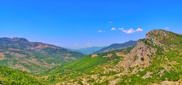 Scenic view of mountains against blue sky