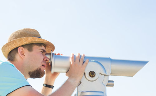 Side view of man drinking water against clear sky