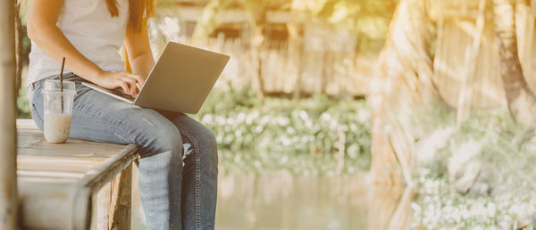 Midsection of woman using mobile phone outdoors