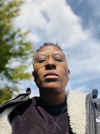 Portrait of young man wearing sunglasses against sky