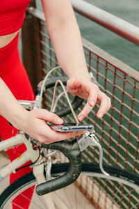 Midsection of man holding bicycle on railing