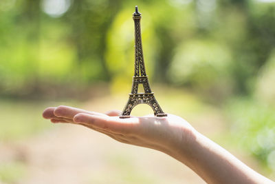 Close-up of hand holding model eiffel tower