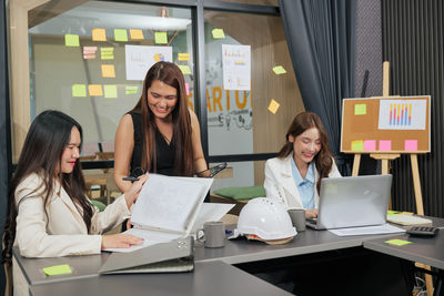 Portrait of woman using laptop at office