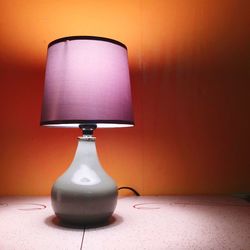Close-up of illuminated lamp on table at home