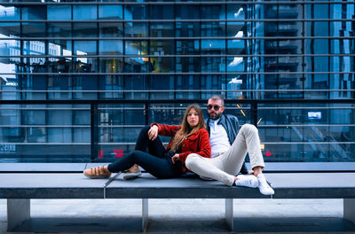 Full length of young man sitting in city