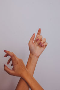 Cropped image of hand on wall against white background
