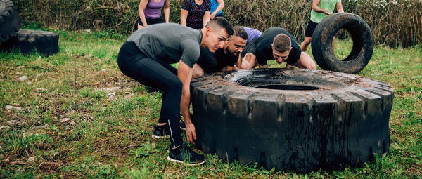 Strong men turning large tire on land