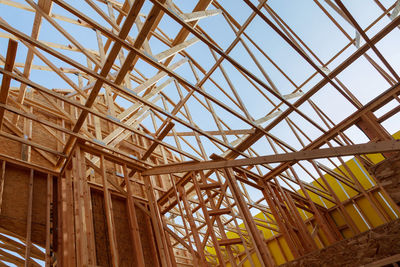 Low angle view of roof beams against sky