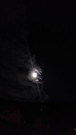 Low angle view of illuminated moon in sky at night