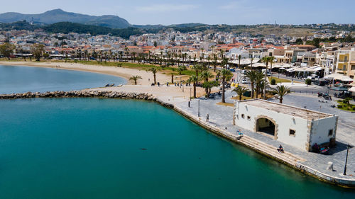 High angle view of townscape by sea against sky