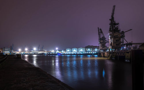 Illuminated commercial dock against sky at night