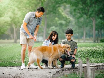 Rear view of people with dog outdoors