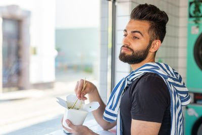 Portrait of young man holding food