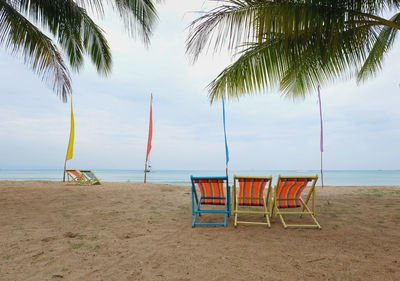 Chairs on beach against sky