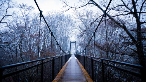 Rear view of man walking on footbridge