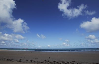 Scenic view of beach against blue sky