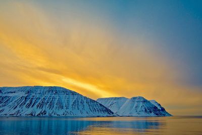 Scenic view of lake against mountain during sunset