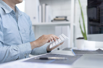 Midsection of man using laptop at office