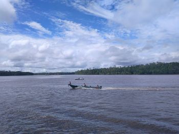 Boats sailing in sea against sky