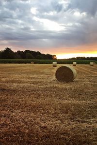 Hay bales on field against sky