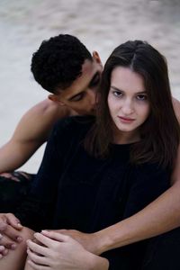 Portrait of young couple sitting at beach