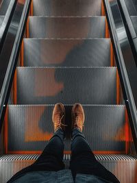 Low section of man standing on escalator