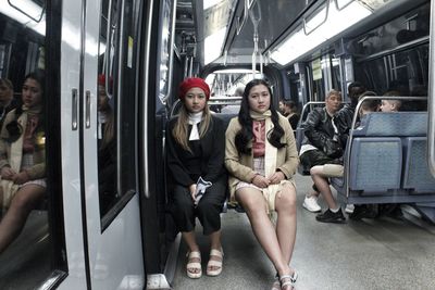 Portrait of friends sitting on train