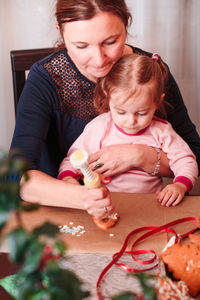 Mother and daughter preparing gingerbread cookies at home