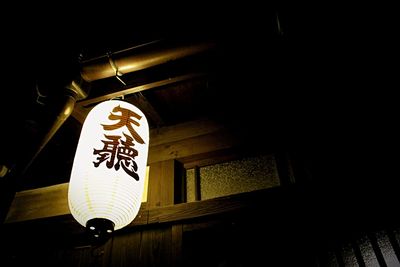 Low angle view of illuminated lantern hanging at night