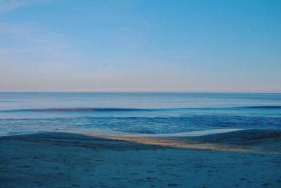 Scenic view of beach against clear blue sky