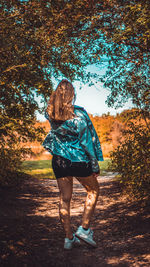 Full length rear view of woman walking on street