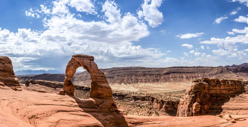 Rock formations on landscape against cloudy sky