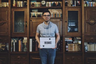 Portrait of young man standing at home