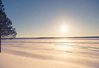 Scenic view of frozen lake against sky during sunset