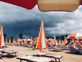 Panoramic view of chairs on beach against sky