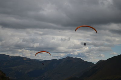 Low angle view of man paragliding against sky