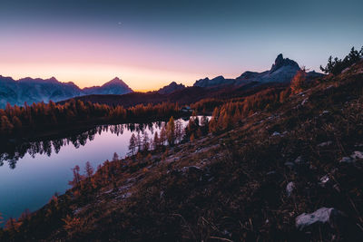 Scenic view of lake and mountains against sky at sunset