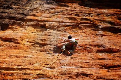 Low angle view of man climbing on mountain