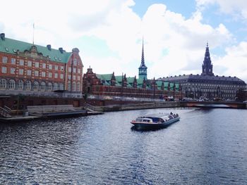 Boats in river with buildings in background