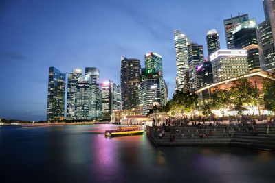 Illuminated buildings in city against sky at night